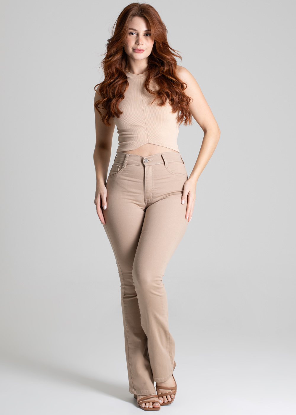 Modelo usando calça flare bege frontal em movimento